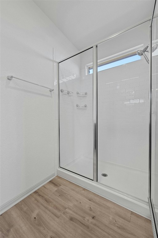 bathroom with an enclosed shower and wood-type flooring