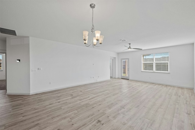 unfurnished living room with ceiling fan with notable chandelier and light wood-type flooring