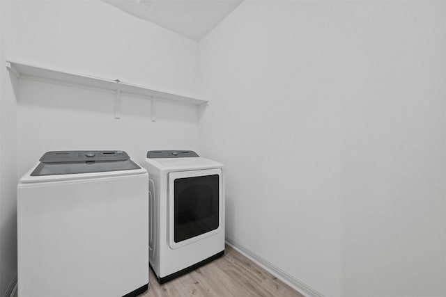 washroom featuring washing machine and dryer and light wood-type flooring