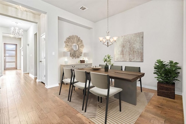 dining area featuring a notable chandelier and light wood-type flooring