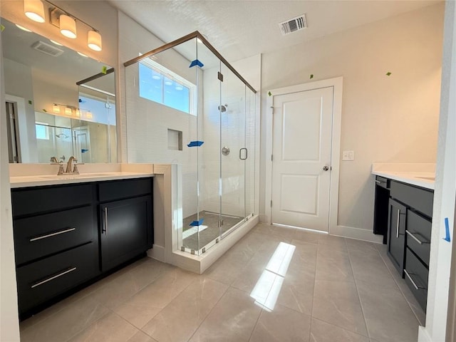 full bathroom featuring visible vents, baseboards, a shower stall, and vanity