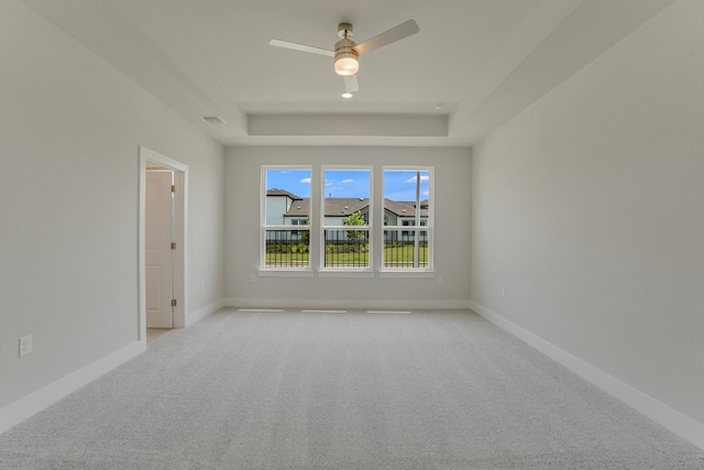 8504 Dongan Dr, Austin, TX 78744 - spare room with light carpet, a tray ceiling, and ceiling fan