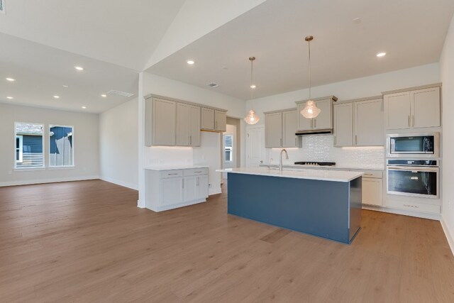 8504 Dongan Dr, Austin, TX 78744 - kitchen featuring stainless steel appliances, light wood finished floors, backsplash, light countertops, and recessed lighting