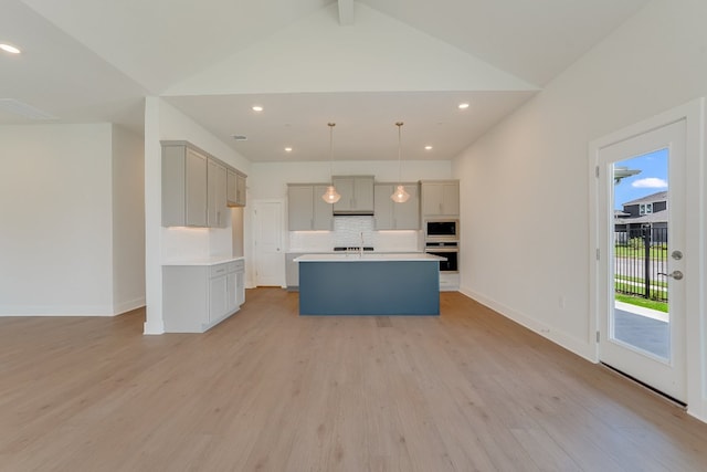 8504 Dongan Dr, Austin, TX 78744 - kitchen featuring oven, decorative backsplash, gray cabinets, light wood-style floors, and built in microwave