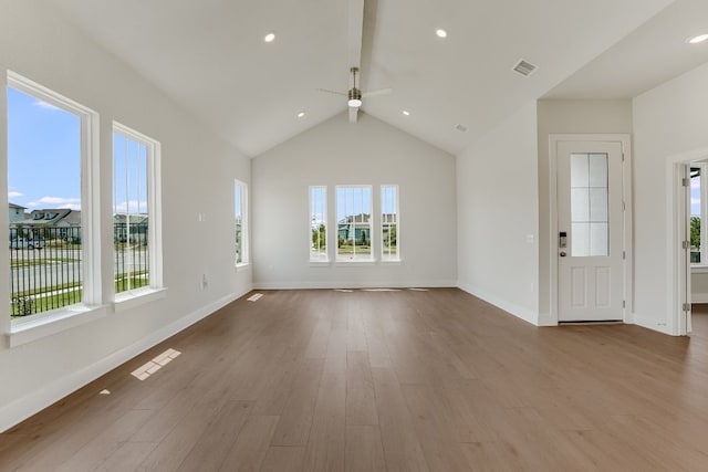 8504 Dongan Dr, Austin, TX 78744 - unfurnished living room featuring healthy amount of natural light, a ceiling fan, wood finished floors, baseboards, and lofted ceiling
