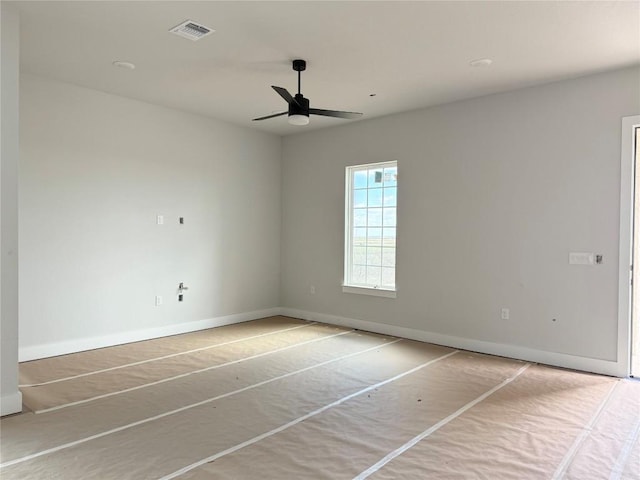 unfurnished room featuring visible vents, ceiling fan, and baseboards