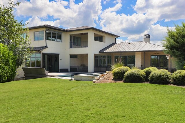 back of property with a balcony and a lawn