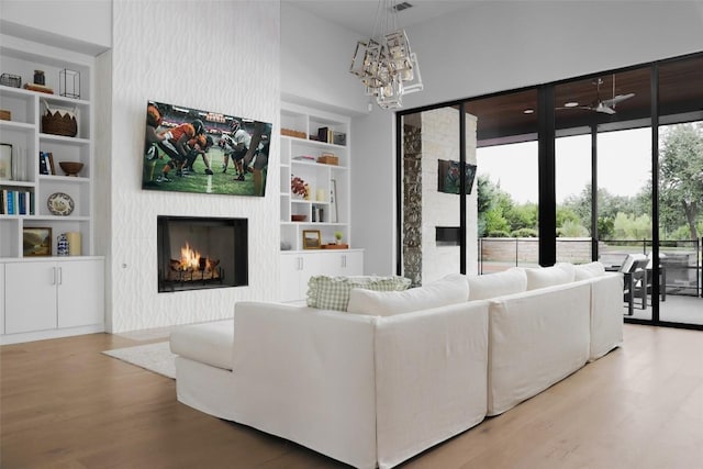 living room with a chandelier, hardwood / wood-style floors, and built in features