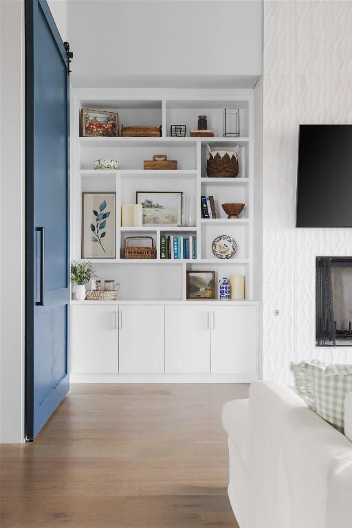 interior space featuring built in shelves, a barn door, and light hardwood / wood-style flooring