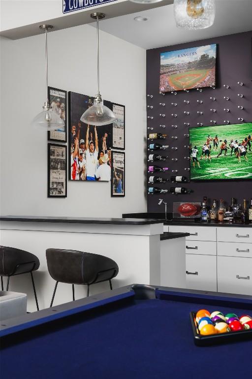 bar featuring white cabinets, decorative light fixtures, and pool table