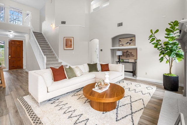 living room with a high ceiling and light wood-type flooring