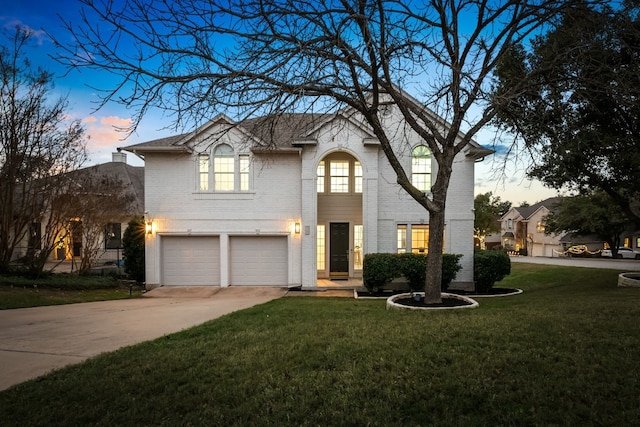 view of front of home with a garage and a yard