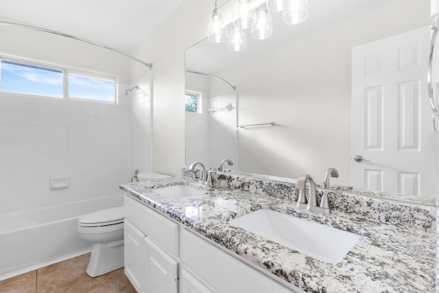 full bathroom featuring tile patterned flooring, tiled shower / bath combo, toilet, and vanity