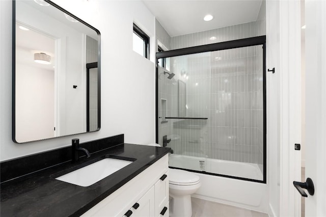 full bathroom with shower / bath combination with glass door, tile patterned floors, vanity, and toilet