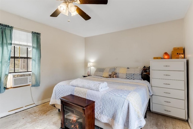 bedroom featuring light hardwood / wood-style flooring, ceiling fan, and cooling unit