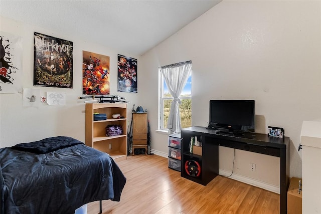 bedroom with hardwood / wood-style floors and vaulted ceiling