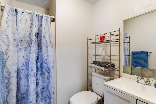 bathroom featuring vanity, a shower with shower curtain, a textured ceiling, and toilet