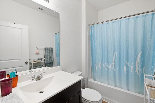 full bathroom with shower / tub combo, vanity, and toilet