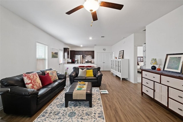 living room with ceiling fan and dark wood-type flooring