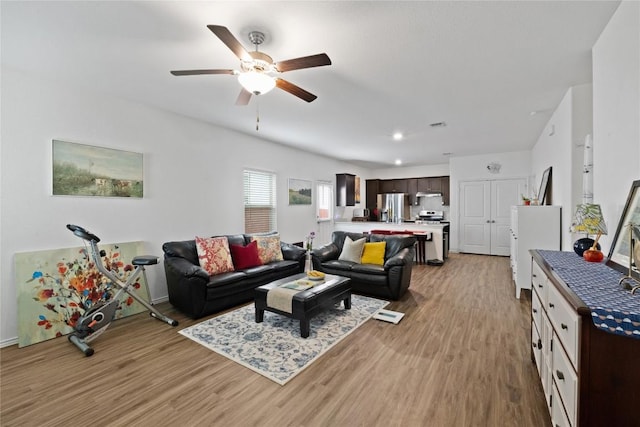 living room featuring ceiling fan and light hardwood / wood-style flooring