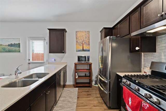 kitchen featuring dark brown cabinets, light hardwood / wood-style floors, sink, and appliances with stainless steel finishes