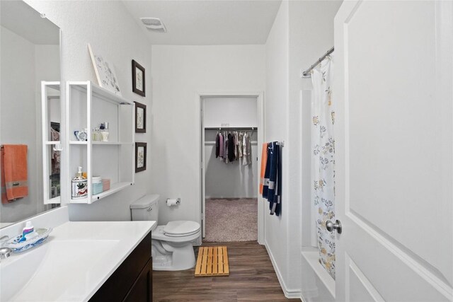 full bathroom featuring hardwood / wood-style floors, vanity, toilet, and shower / bath combo with shower curtain