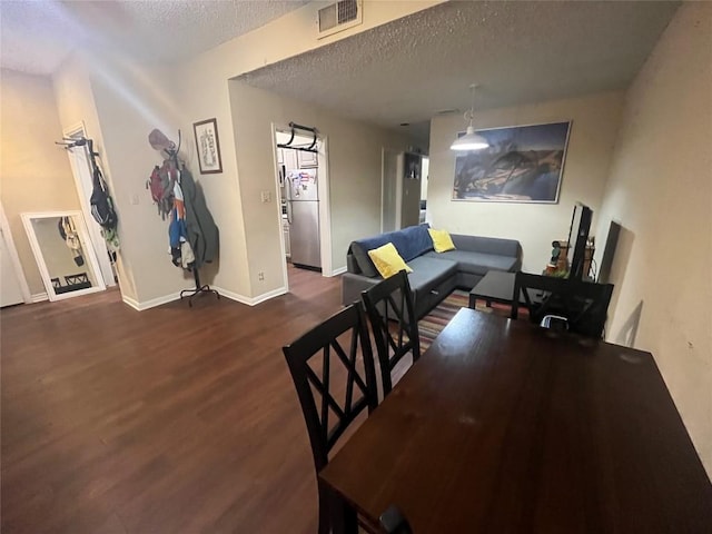 dining space featuring a textured ceiling and dark hardwood / wood-style floors