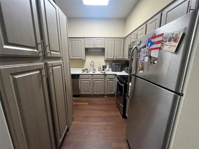 kitchen with gray cabinetry, sink, stainless steel appliances, and dark hardwood / wood-style flooring