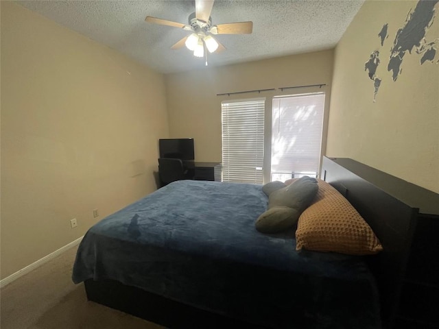 carpeted bedroom with ceiling fan and a textured ceiling