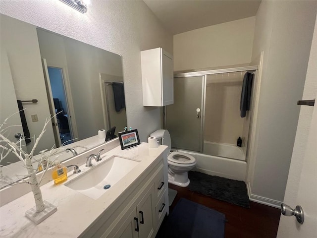 full bathroom featuring hardwood / wood-style floors, vanity, toilet, and shower / bath combination with glass door