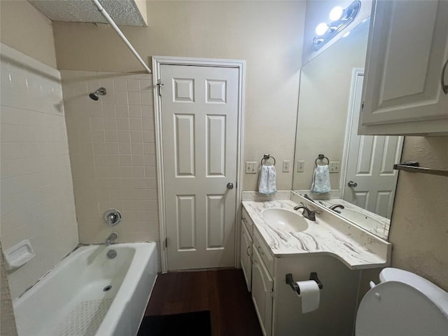 full bathroom with hardwood / wood-style flooring, vanity, toilet, and tiled shower / bath