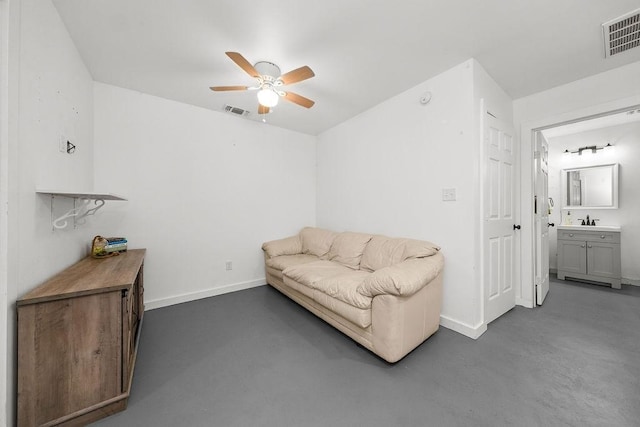 living area featuring ceiling fan and sink