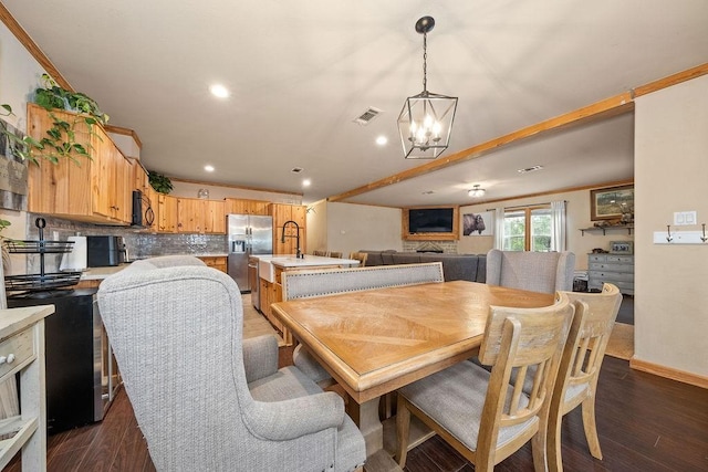 dining space featuring ornamental molding, dark wood-type flooring, and a chandelier