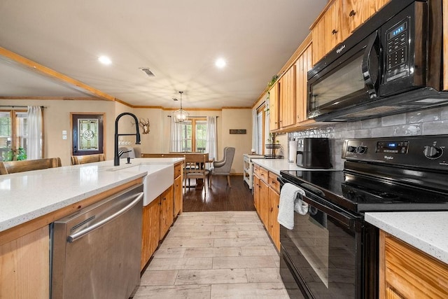 kitchen featuring light stone countertops, hanging light fixtures, crown molding, a chandelier, and black appliances