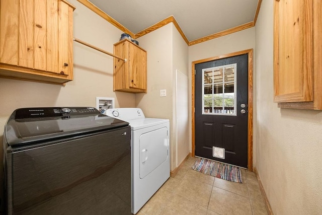 washroom featuring cabinets, washer and dryer, ornamental molding, and light tile patterned flooring