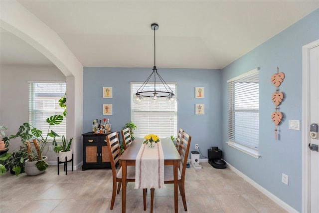 dining space with a notable chandelier and lofted ceiling