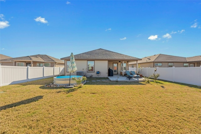 back of property with cooling unit, a trampoline, a patio, and a yard