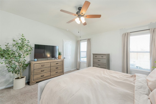 carpeted bedroom with multiple windows, ceiling fan, and vaulted ceiling