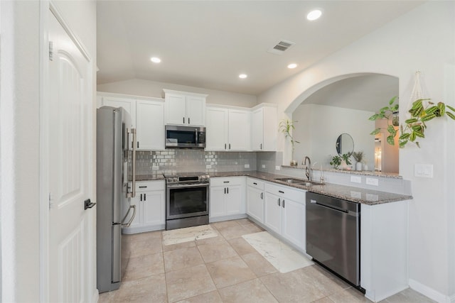 kitchen with backsplash, white cabinetry, sink, and stainless steel appliances