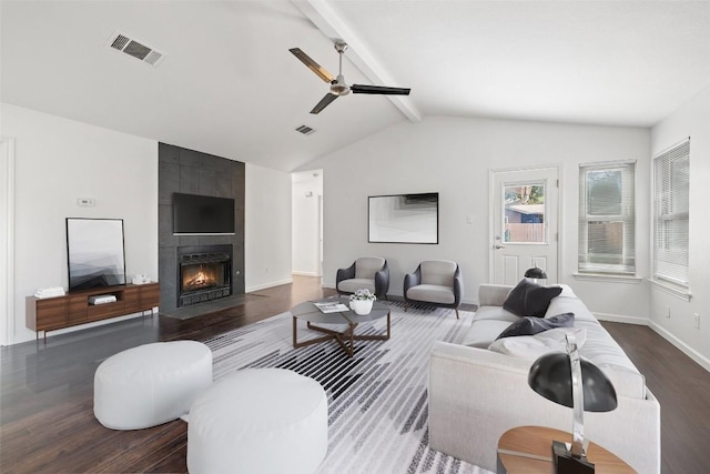 living room featuring dark hardwood / wood-style flooring, ceiling fan, a fireplace, and lofted ceiling with beams