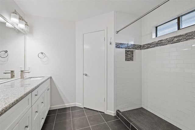 bathroom featuring tile patterned floors, vanity, and tiled shower