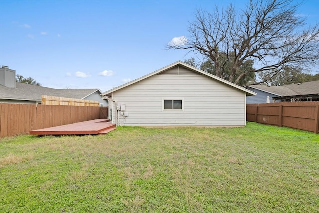 back of house featuring a yard and a wooden deck