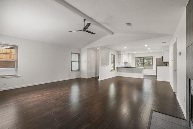 unfurnished living room featuring hardwood / wood-style flooring, lofted ceiling with beams, and ceiling fan