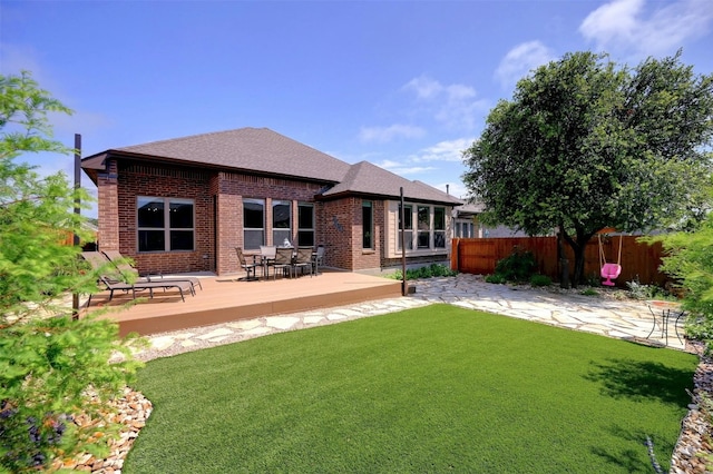 back of property with a wooden deck and a lawn