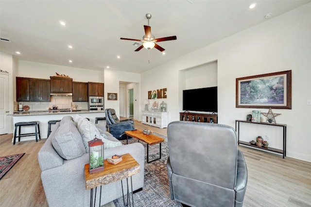 living room featuring ceiling fan and light hardwood / wood-style floors