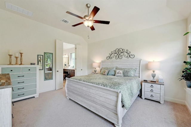 bedroom featuring ceiling fan, light carpet, ensuite bath, and lofted ceiling