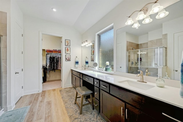 bathroom with a shower with shower door, vanity, and wood-type flooring