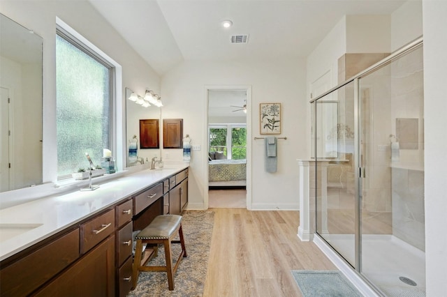 bathroom featuring hardwood / wood-style floors, a shower with door, ceiling fan, lofted ceiling, and vanity