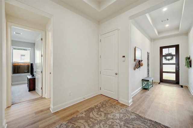 entrance foyer featuring light hardwood / wood-style floors and a raised ceiling