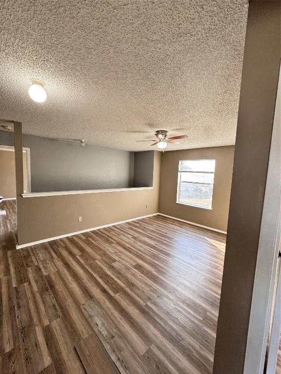 empty room featuring ceiling fan, dark hardwood / wood-style flooring, and a textured ceiling